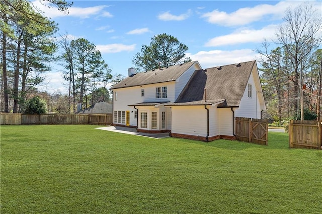 rear view of house with a lawn, a fenced backyard, french doors, a chimney, and a patio area