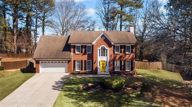 colonial inspired home with a garage, brick siding, a front lawn, and fence