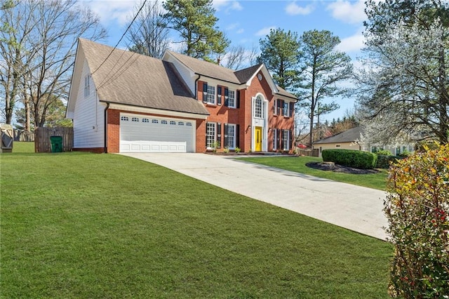 colonial house with fence, concrete driveway, an attached garage, a front yard, and brick siding