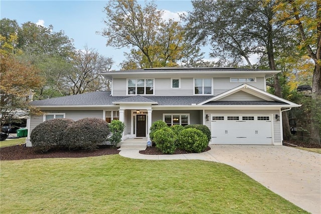 traditional-style house with concrete driveway, a garage, and a front yard