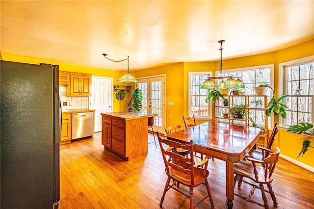 dining room with french doors and light hardwood / wood-style flooring