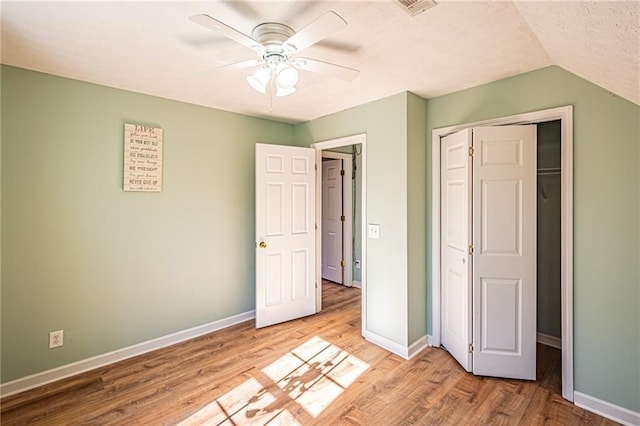 unfurnished bedroom with lofted ceiling, light hardwood / wood-style floors, a closet, and ceiling fan