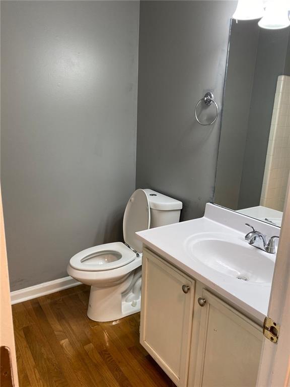 bathroom featuring vanity, wood-type flooring, and toilet