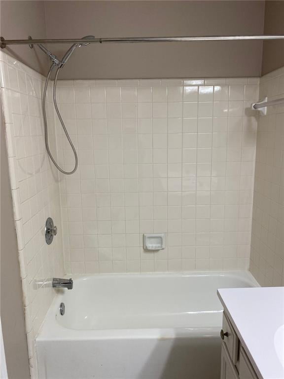 bathroom with tiled shower / bath combo and vanity