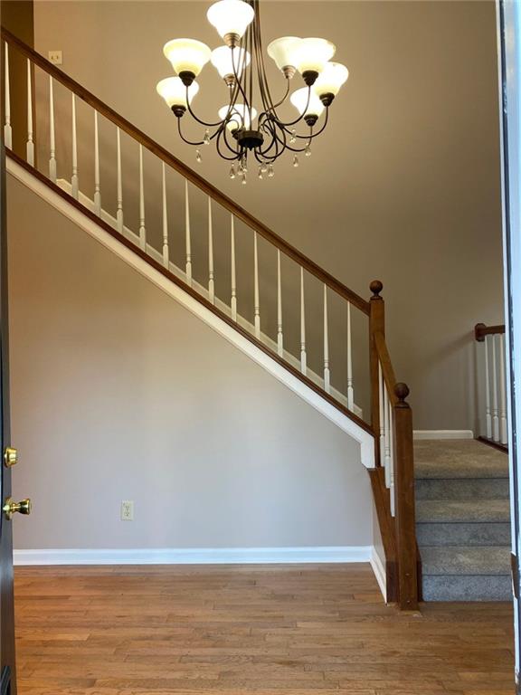 stairway featuring hardwood / wood-style floors and a chandelier