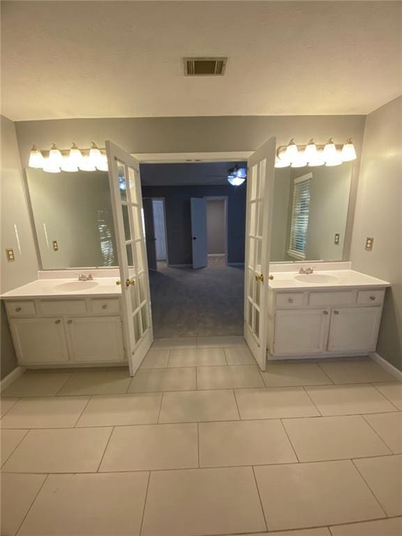 bathroom with french doors, tile patterned floors, and vanity