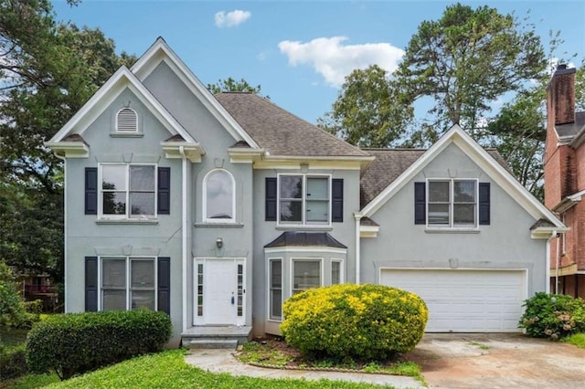 4467 Boatmans Cv, Stone Mountain, GA 30083 - view of front of house with stucco siding, a garage, roof with shingles, and concrete driveway