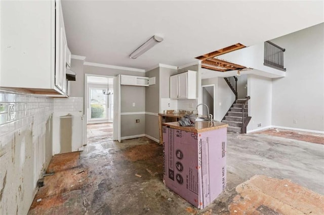 4467 Boatmans Cv, Stone Mountain, GA 30083 - kitchen featuring white cabinets, ornamental molding, a peninsula, and backsplash