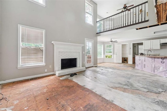 4467 Boatmans Cv, Stone Mountain, GA 30083 - unfurnished living room featuring a ceiling fan, a towering ceiling, and a brick fireplace