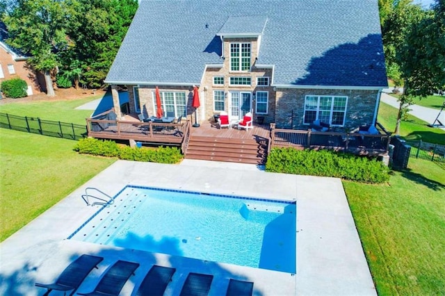 back of property featuring a swimming pool side deck and a lawn