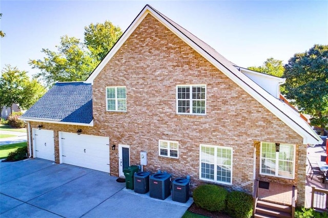 view of side of property with a garage and cooling unit