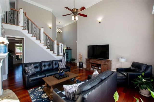 living room featuring dark wood-type flooring, a towering ceiling, and crown molding