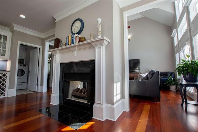 living room with washer / clothes dryer, a multi sided fireplace, hardwood / wood-style flooring, and lofted ceiling