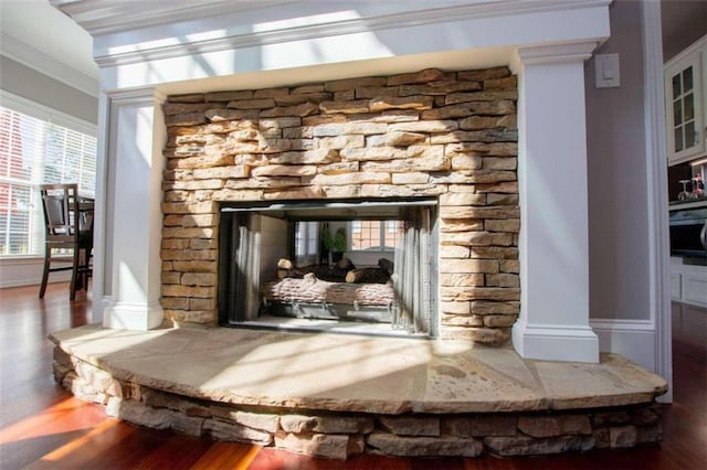 interior details with ornamental molding, decorative columns, a fireplace, and hardwood / wood-style floors