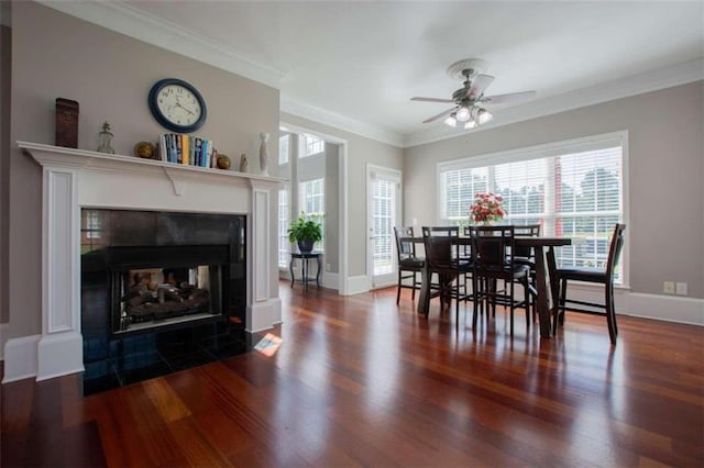 dining room featuring crown molding, a multi sided fireplace, ceiling fan, and hardwood / wood-style floors