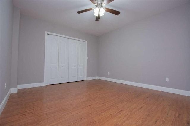 unfurnished bedroom featuring light hardwood / wood-style floors, a closet, and ceiling fan