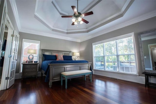 bedroom featuring ceiling fan, hardwood / wood-style flooring, ornamental molding, and a tray ceiling