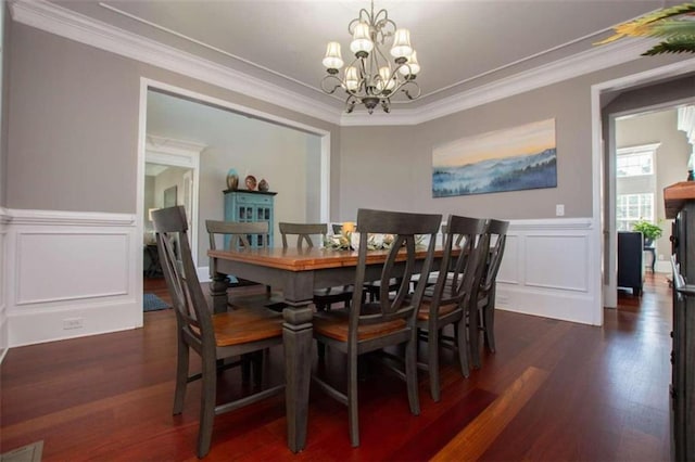 dining room with ornamental molding, a chandelier, and dark wood-type flooring