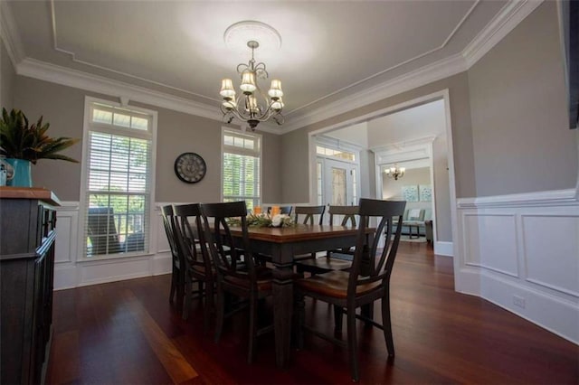 dining space featuring dark hardwood / wood-style flooring, an inviting chandelier, and crown molding