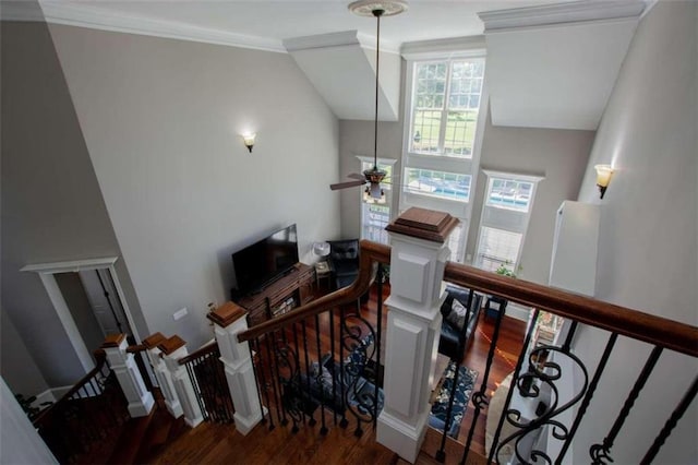 staircase featuring ceiling fan, crown molding, hardwood / wood-style flooring, and lofted ceiling