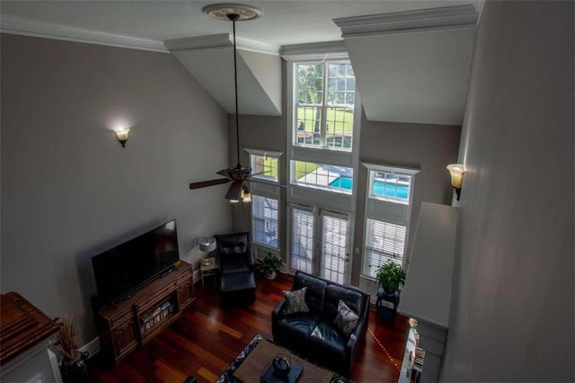 living room featuring dark wood-type flooring, crown molding, and ceiling fan