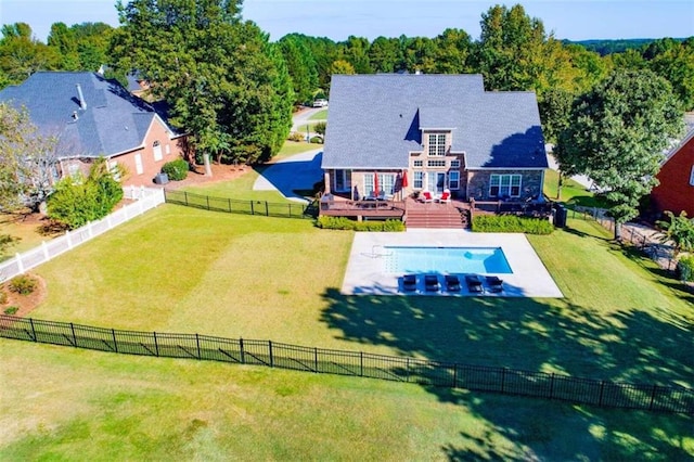 view of swimming pool featuring a deck and a lawn