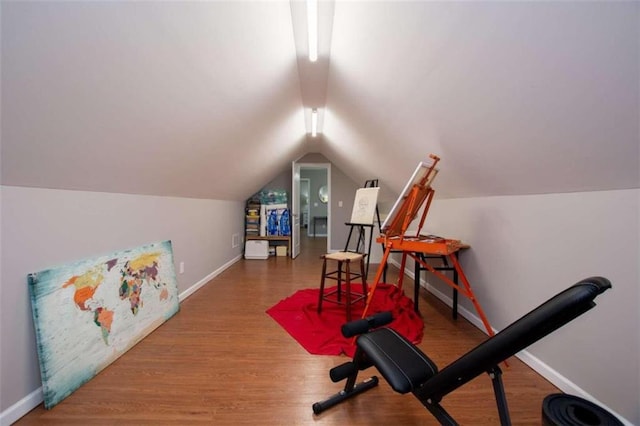 exercise room featuring lofted ceiling and hardwood / wood-style floors