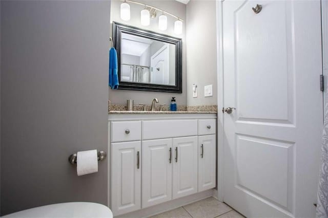 bathroom featuring vanity, tile patterned floors, and toilet