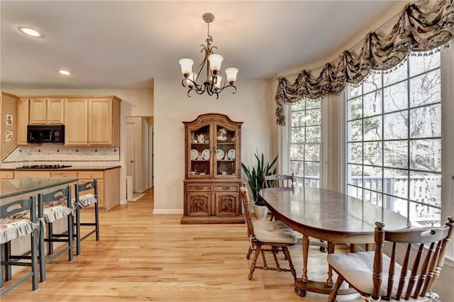 dining area featuring a notable chandelier, light wood-style floors, and recessed lighting