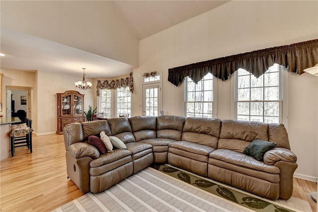 living room featuring a chandelier, light wood-type flooring, and baseboards