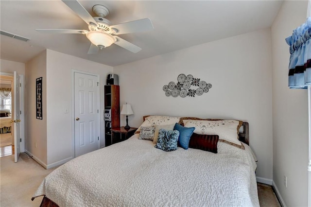 bedroom with visible vents, light carpet, baseboards, and a ceiling fan