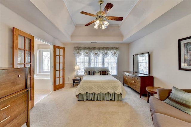 bedroom with light carpet, multiple windows, crown molding, and a tray ceiling