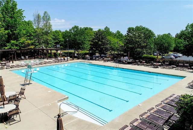 pool with a patio and fence