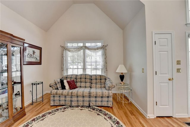 living area with lofted ceiling, light wood-style floors, and baseboards