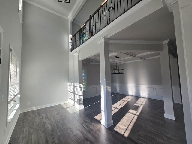 empty room with beam ceiling, dark hardwood / wood-style floors, ornamental molding, and coffered ceiling