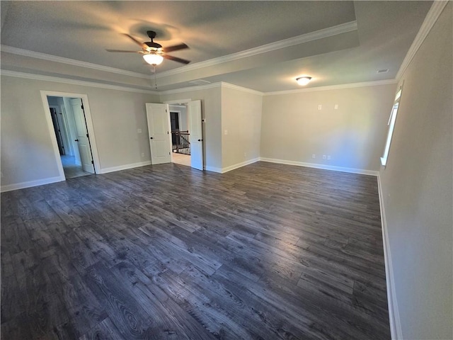 spare room with a raised ceiling, crown molding, dark hardwood / wood-style flooring, and ceiling fan