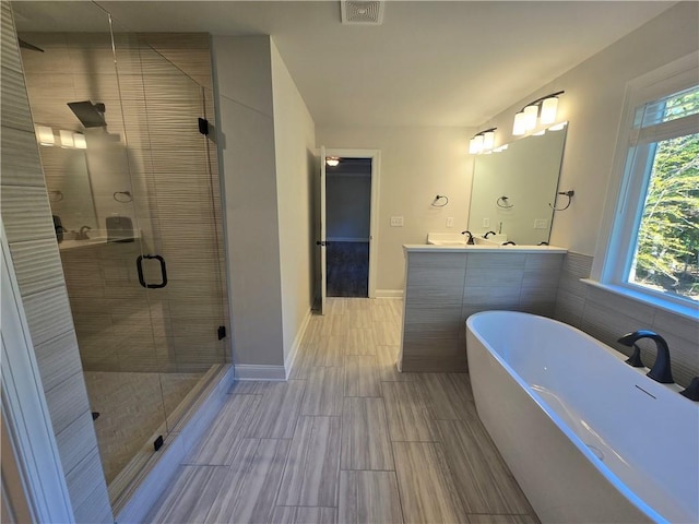 bathroom featuring vanity and separate shower and tub