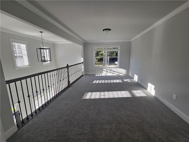 carpeted empty room featuring crown molding and an inviting chandelier