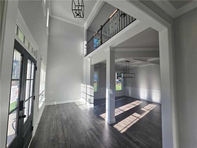 entrance foyer with ornamental molding, a wealth of natural light, and dark wood-type flooring