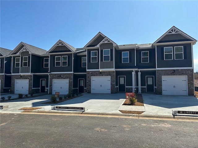 multi unit property featuring an attached garage, board and batten siding, and concrete driveway