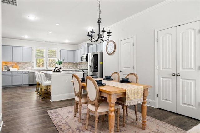 309 Vista Ln, Woodstock, GA 30189 - dining room featuring an inviting chandelier, dark wood-type flooring, visible vents, and crown molding