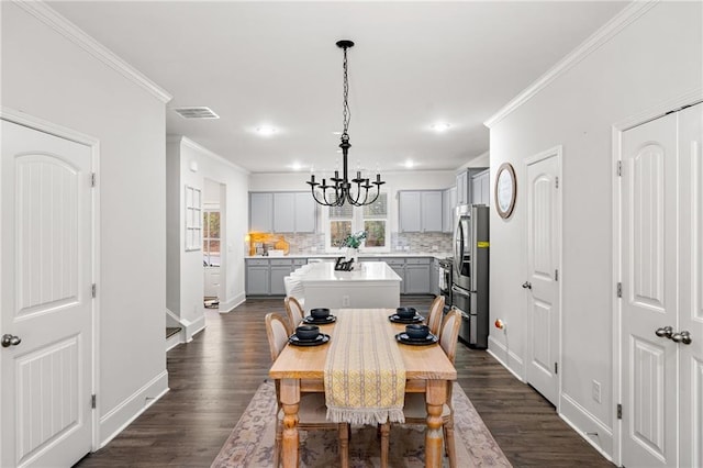 309 Vista Ln, Woodstock, GA 30189 - dining room with visible vents, an inviting chandelier, crown molding, and dark wood-style floors