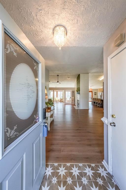 foyer entrance with a chandelier, a textured ceiling, and tile patterned floors