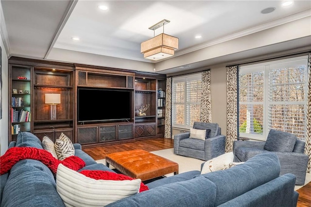 living room featuring hardwood / wood-style flooring, ornamental molding, and a wealth of natural light