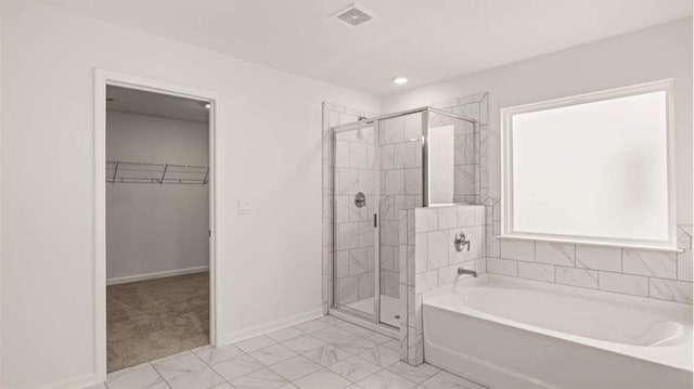 13567 Whitman Ln, Covington, GA 30014 - bathroom with a bath, a stall shower, a spacious closet, baseboards, and marble finish floors