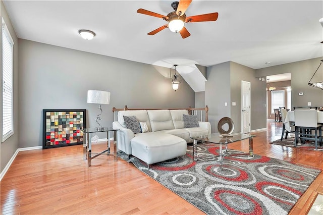 living area featuring ceiling fan, baseboards, and wood finished floors