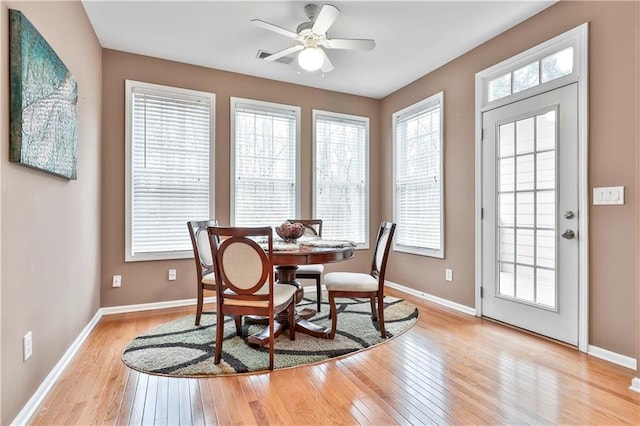 dining space with a healthy amount of sunlight, light wood-style flooring, and baseboards