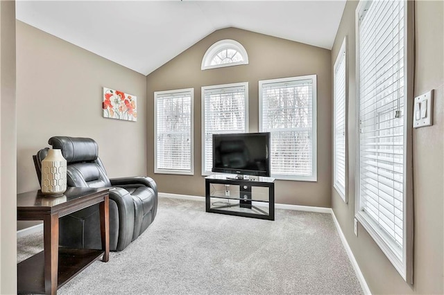 living area with carpet, baseboards, and vaulted ceiling