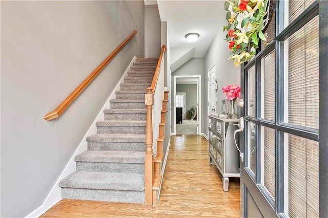 stairway featuring baseboards and wood finished floors