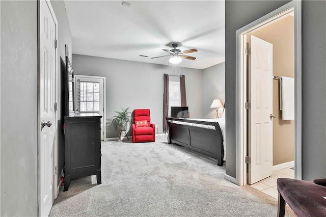 carpeted bedroom featuring a ceiling fan, multiple windows, connected bathroom, and visible vents